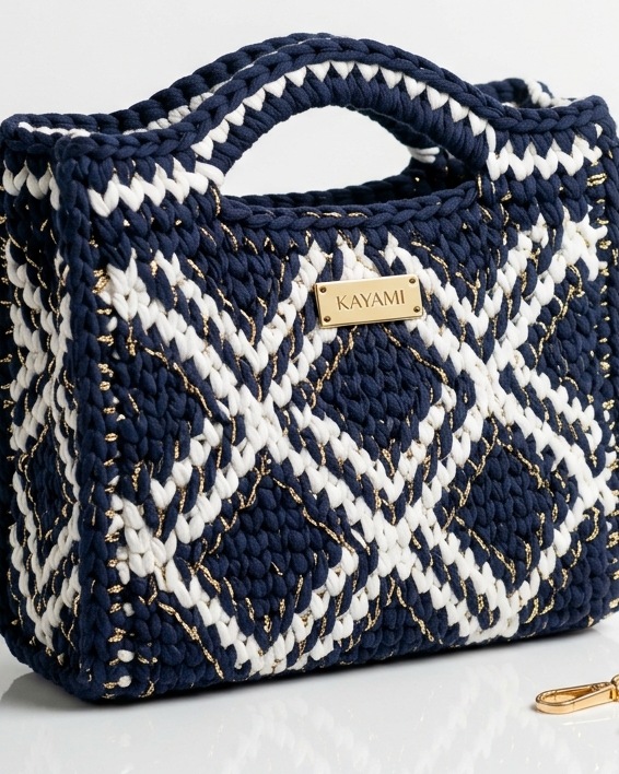 Gros plan sur le tissage au crochet d'un sac KAYAMI marine et blanc, avec sa plaque métal